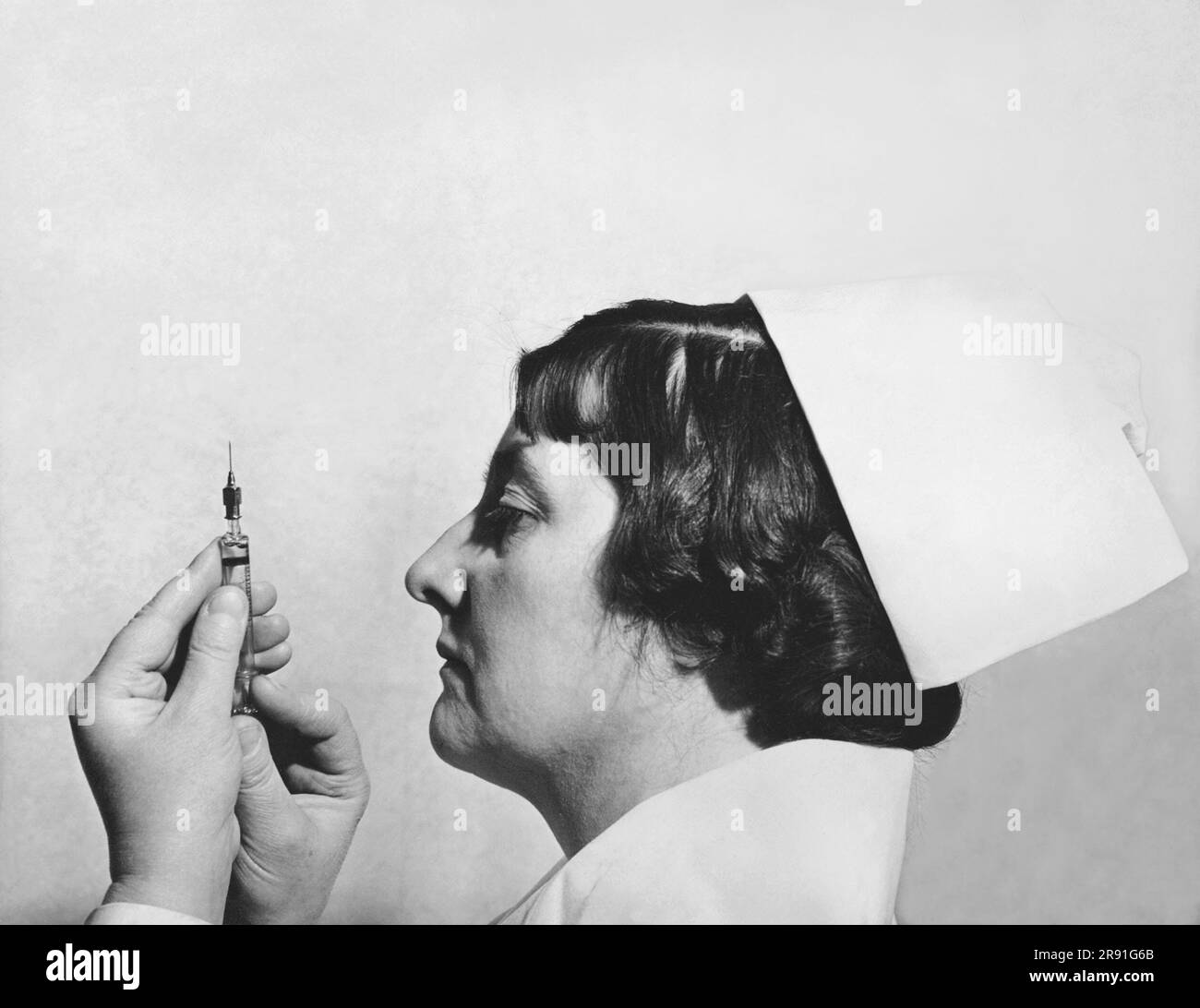 Philadelphia, Pennsylvania:  March 28, 1938 A nurse at the Horace Berk Memorial Hospital prepare an insulin injection for the treatment of insanity. Dr. Manfre Sakel of Vienna discovered three years ago that an 'insulin shot shock treatment' causes the body  to burn its sugar, depriving the brain of its sole source of energy and often induces violent shock which frequently effects a complete cure of the mental ailment. Stock Photo