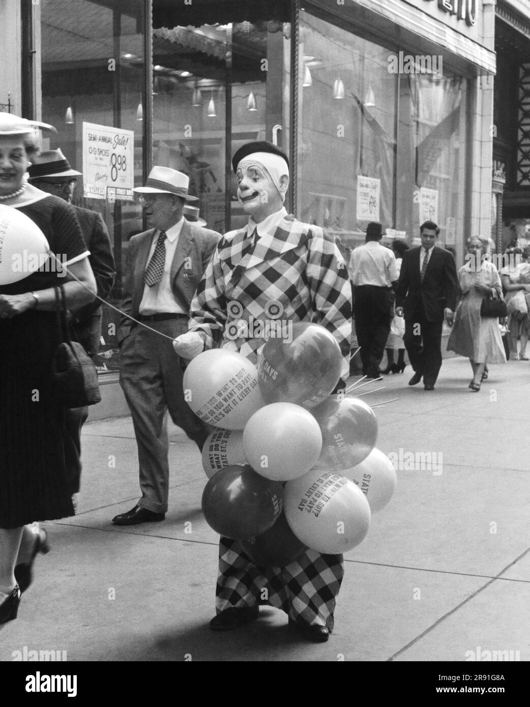 Chicago, Illinois:  August 11, 1956 A man in a clown outfit passing out promotional balloons advertising 'State Street Days'. Stock Photo