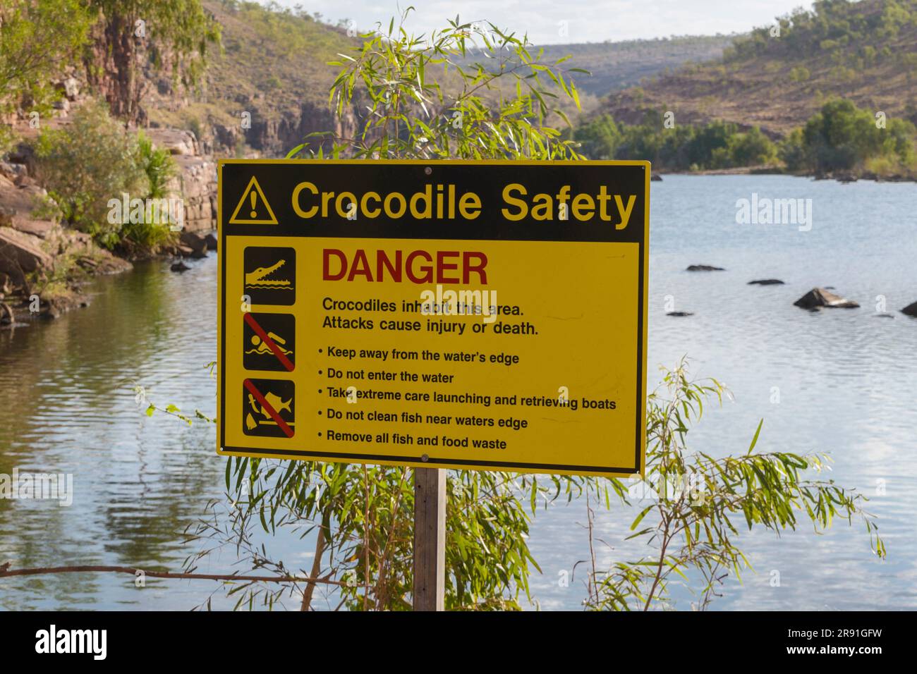 A crocodile safety sign warns people of the danger near the river Chamberlain in Western Australia Stock Photo