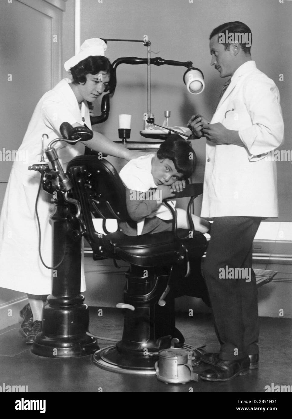 New York, New York:  November 6, 1925 This young man has the honor of being the first patient at the Union Health Center Dental Clinic in NY. The clinic is conducted by the International Ladies' Garment Workers Union. Stock Photo