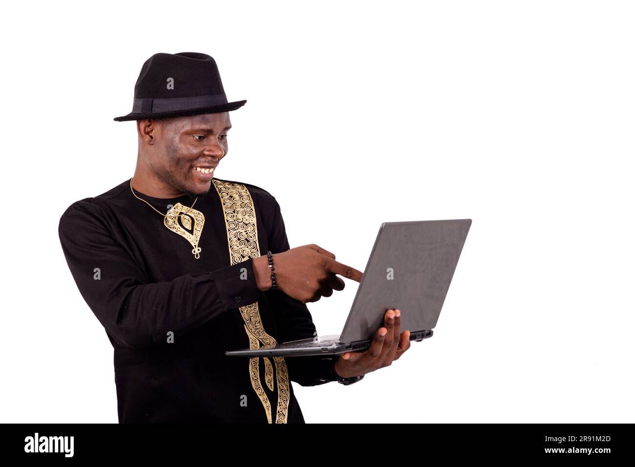 well-dressed young man pointing finger at laptop screen while smiling. Stock Photo