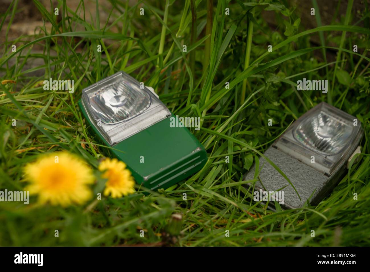 Old hand torch in green grass in spring fresh nice day Stock Photo