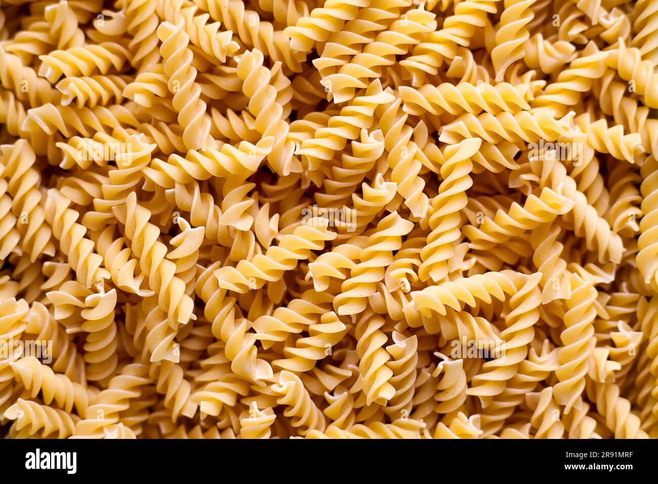 Full-frame close-up on a stack of uncooked fusilli. Stock Photo