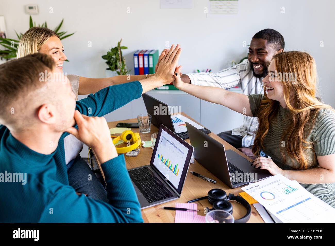 Colleagues Giving High-Five Celebrating Business Success Standing In Office  Stock Photo by ©Milkos 381522740