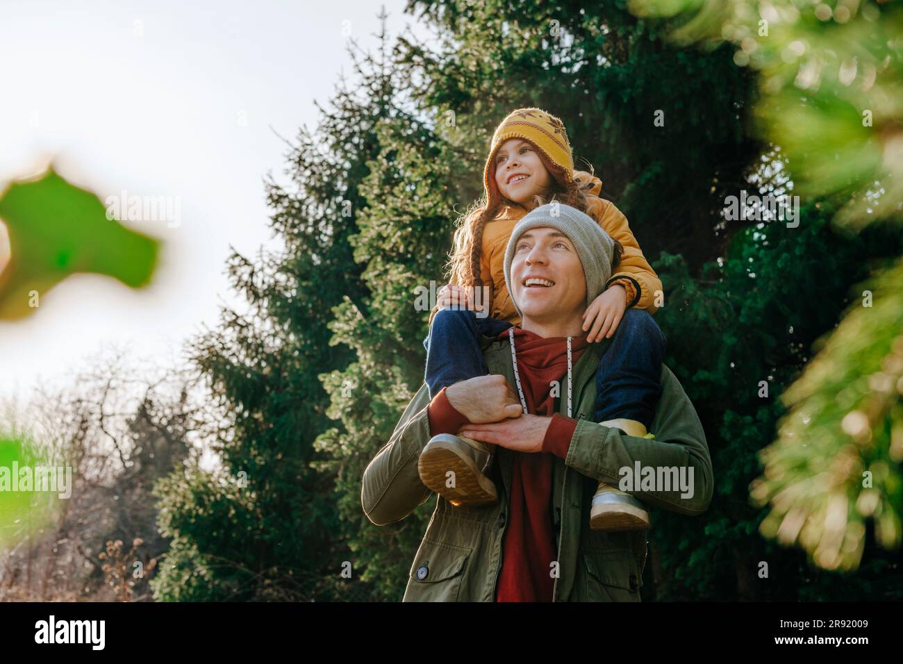 Smiling father carrying daughter on shoulders in forest Stock Photo - Alamy