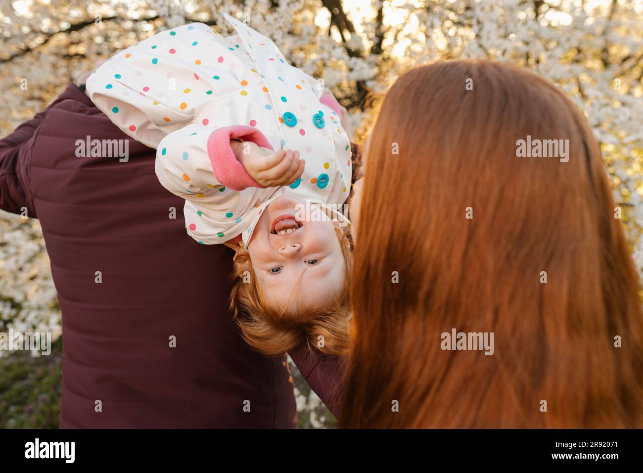 Parents spending leisure time with daughter at park Stock Photo