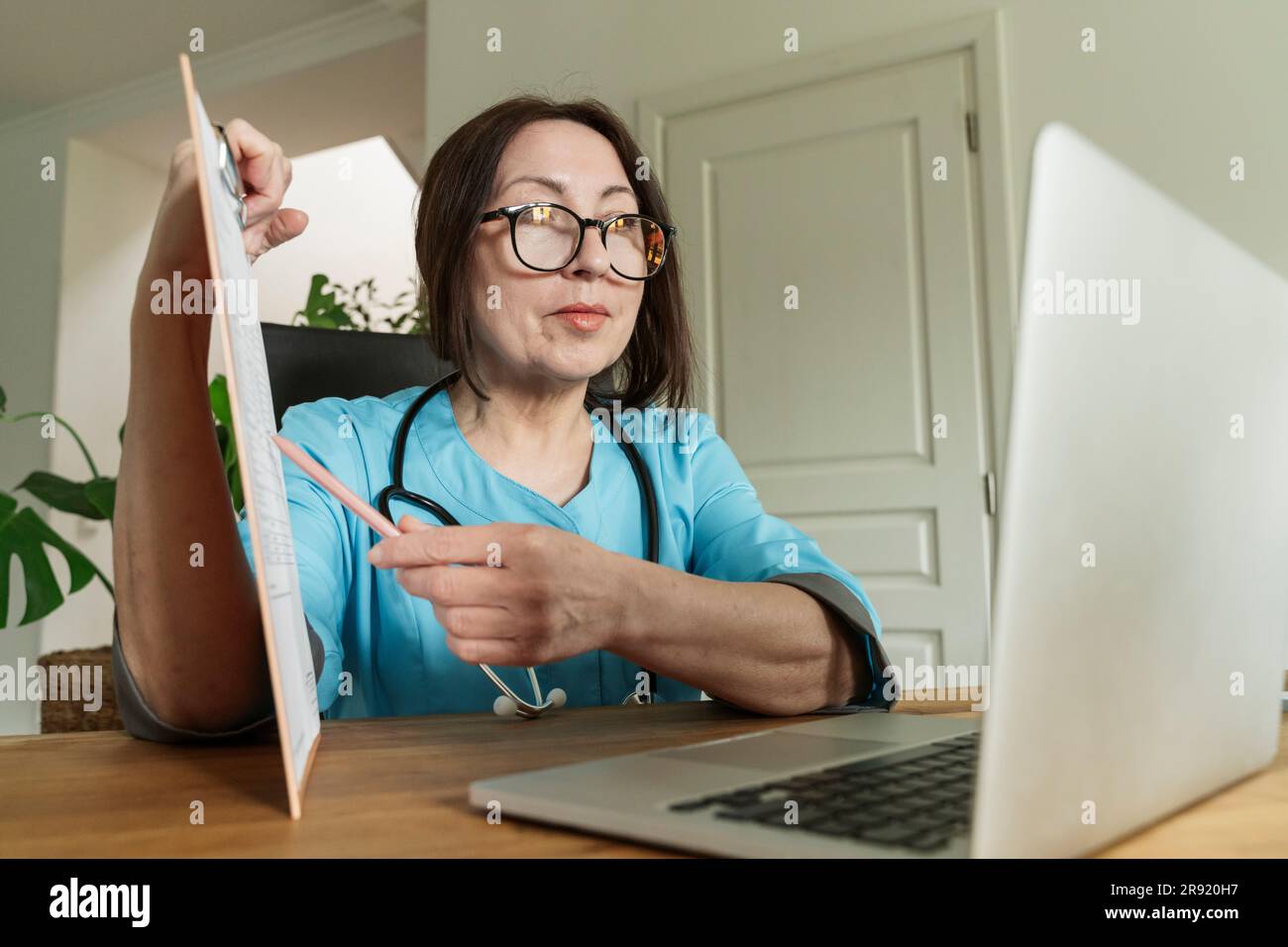 Doctor advising patient through video call on laptop at medical practice Stock Photo