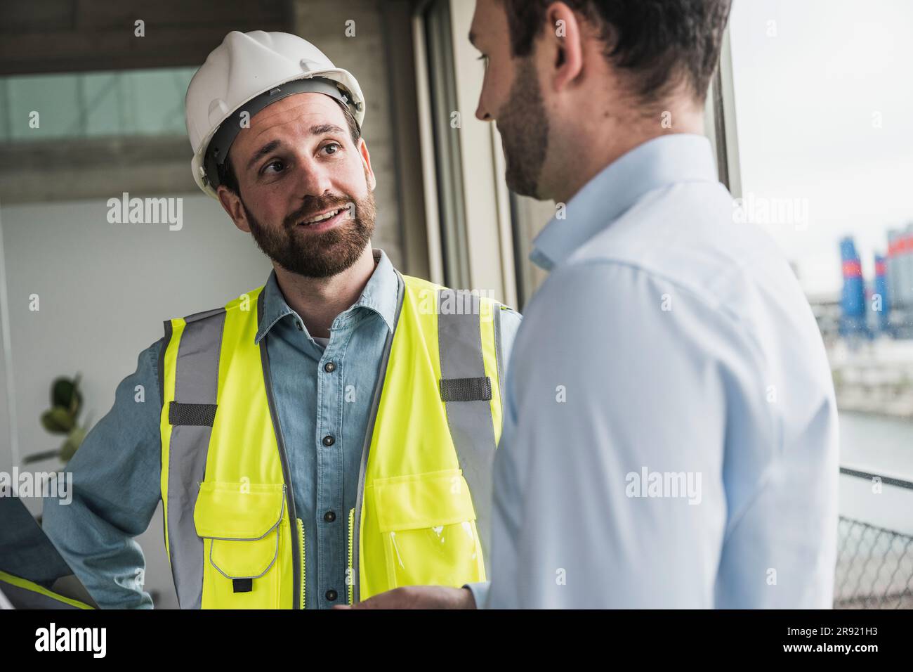 Building contractor discussing with architect at site Stock Photo - Alamy