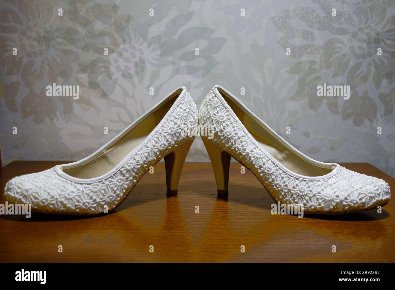 A pair of white wedding shoes in a classic stiletto-heel style, ready to complete the perfect bridal look Stock Photo