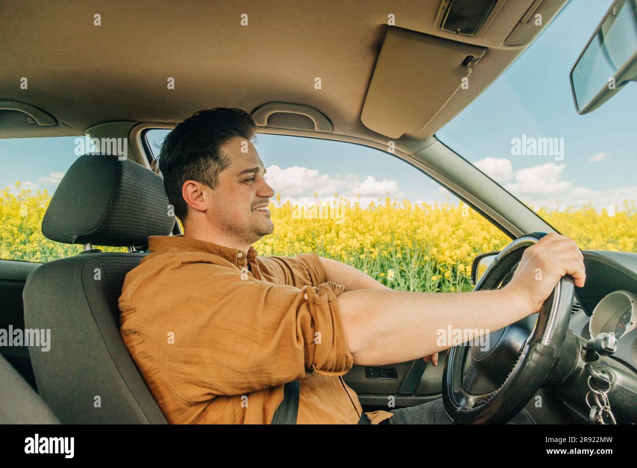 Smiling man holding steering wheel and driving car Stock Photo - Alamy