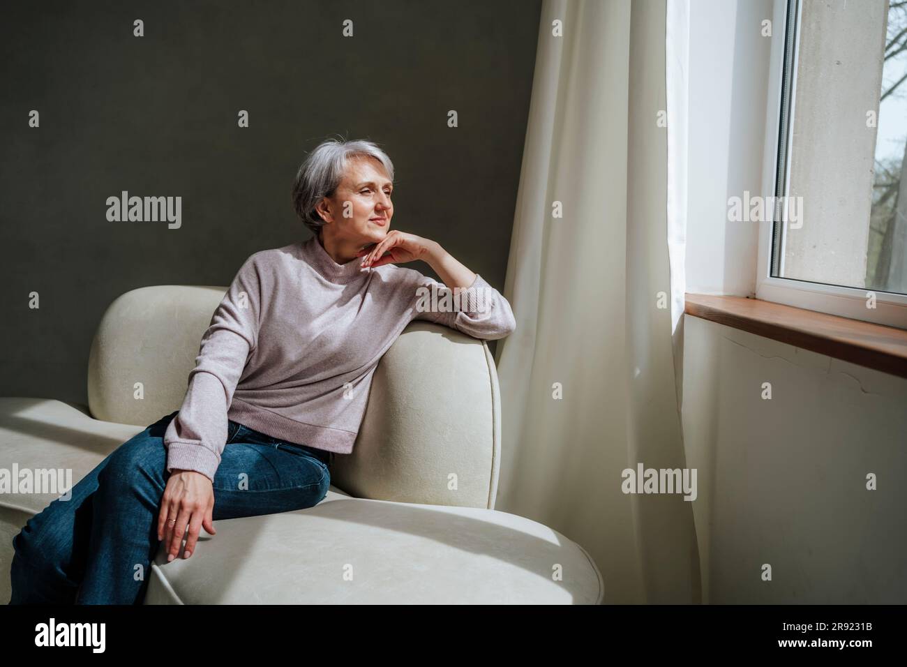 Mature daydreaming woman couch hi-res stock photography and images - Alamy