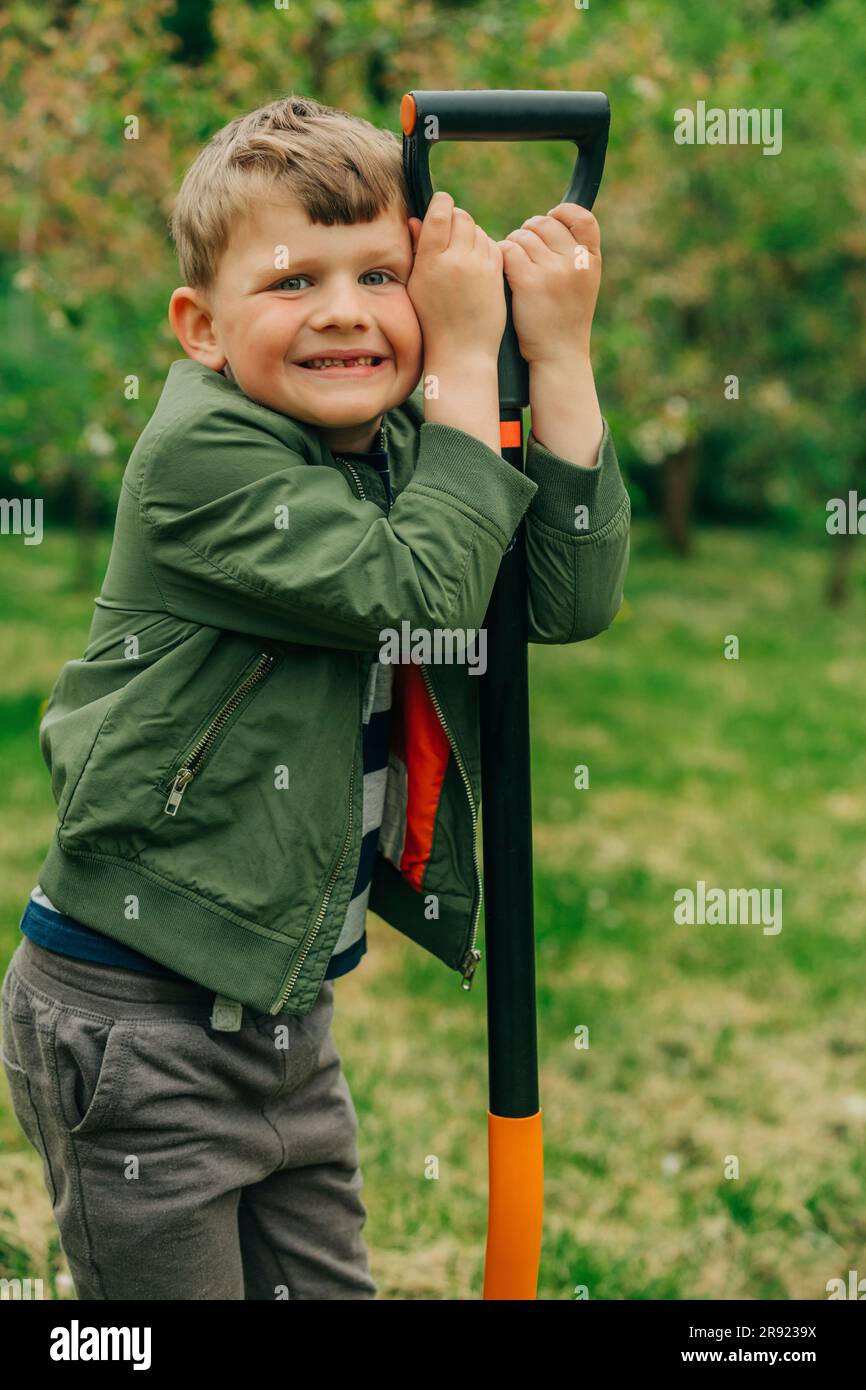 Happy boy standing with shovel in garden Stock Photo - Alamy