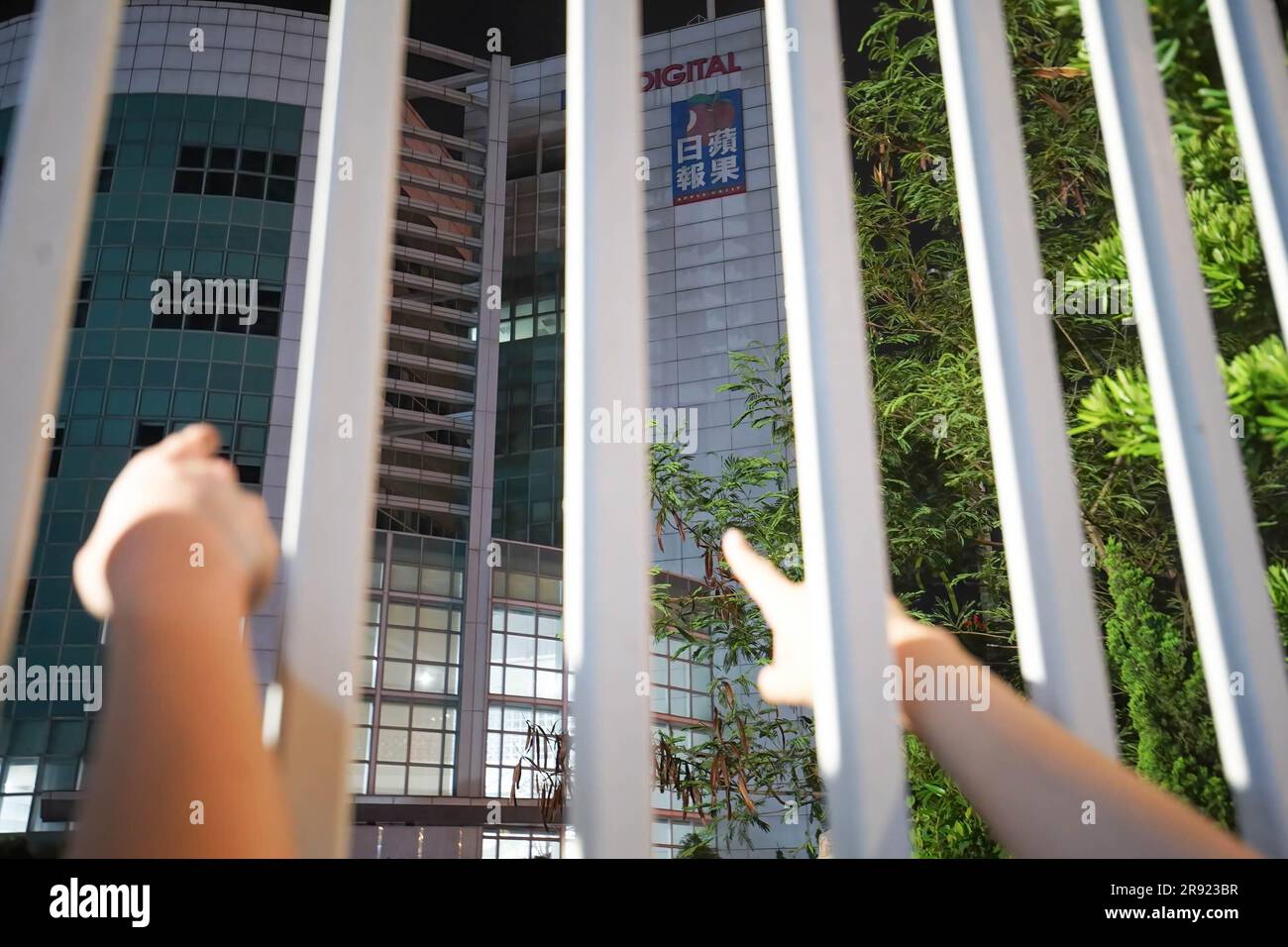 Two former journalists of Apple Daily use fingers to point out their offices before the closure. On the second anniversary of Apple Daily's closure, a group of former journalists gathered at the headquarters of the pro-democracy newspaper to commemorate the occasion. Despite the passage of time, the memories of the newspaper's forced closure under the National Security Law are still fresh in their minds. The journalists, fill with a sense of nostalgia and resilience, stand outside the familiar building and take photos to symbolize their unwavering commitment to press freedom and democracy in H Stock Photo