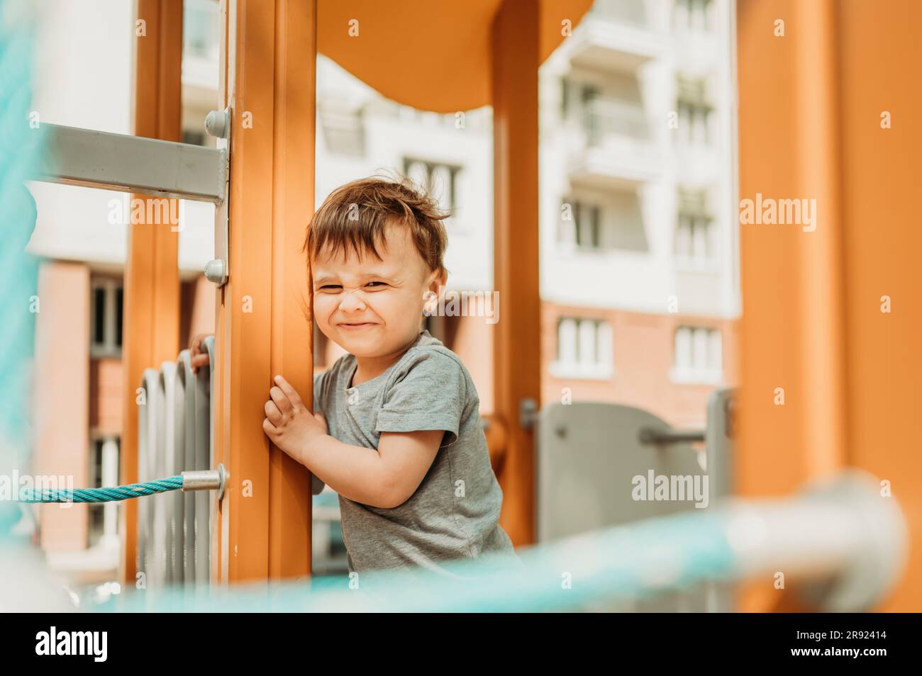 Smiling boy standing on playing equipment at playground Stock Photo