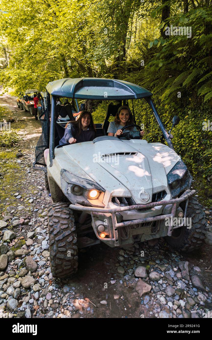 Friends driving buggy and spending vacation at forest Stock Photo