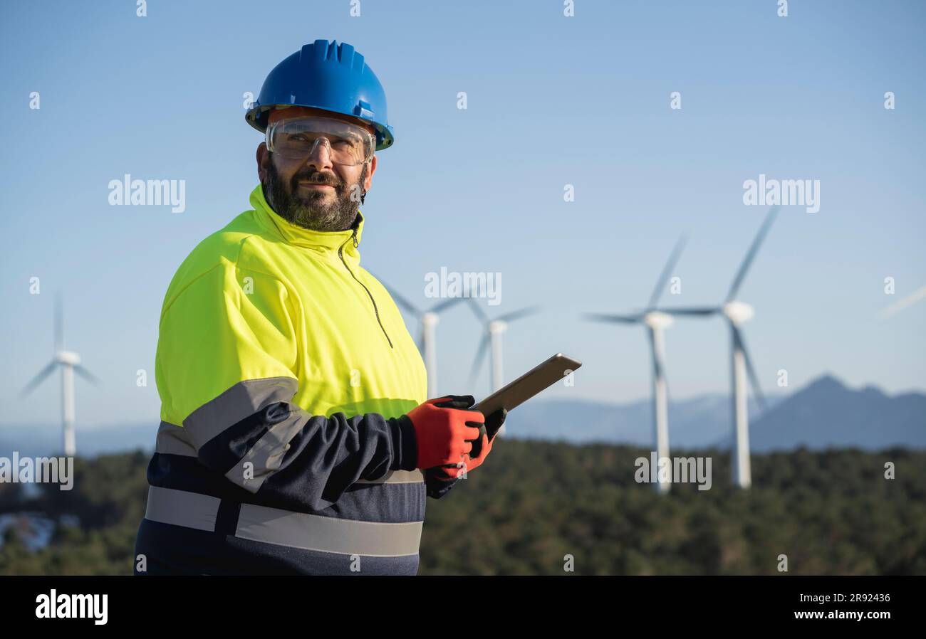 Contemplative engineer holding tablet PC at wind park Stock Photo