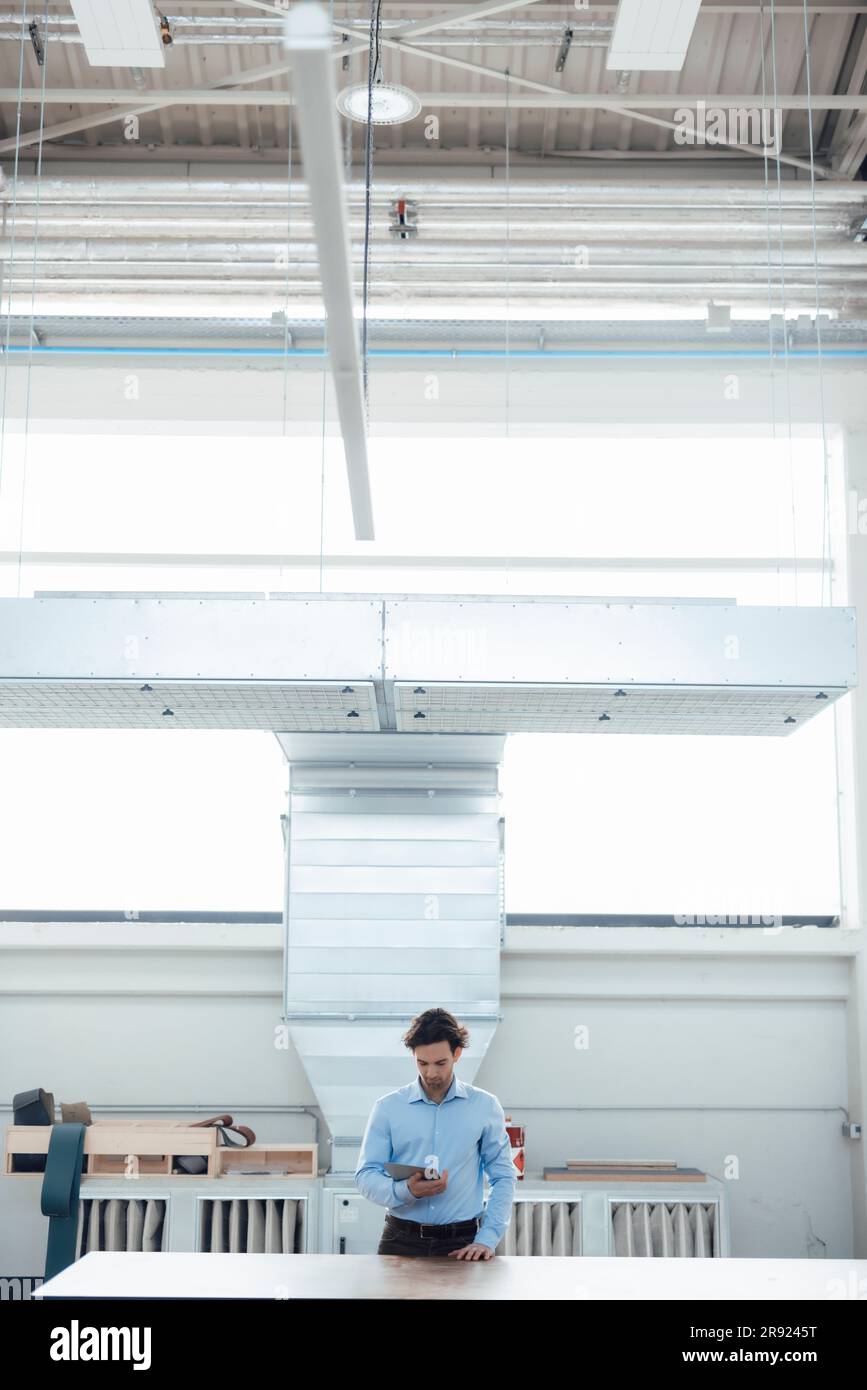 Businessman using tablet PC standing at industry Stock Photo