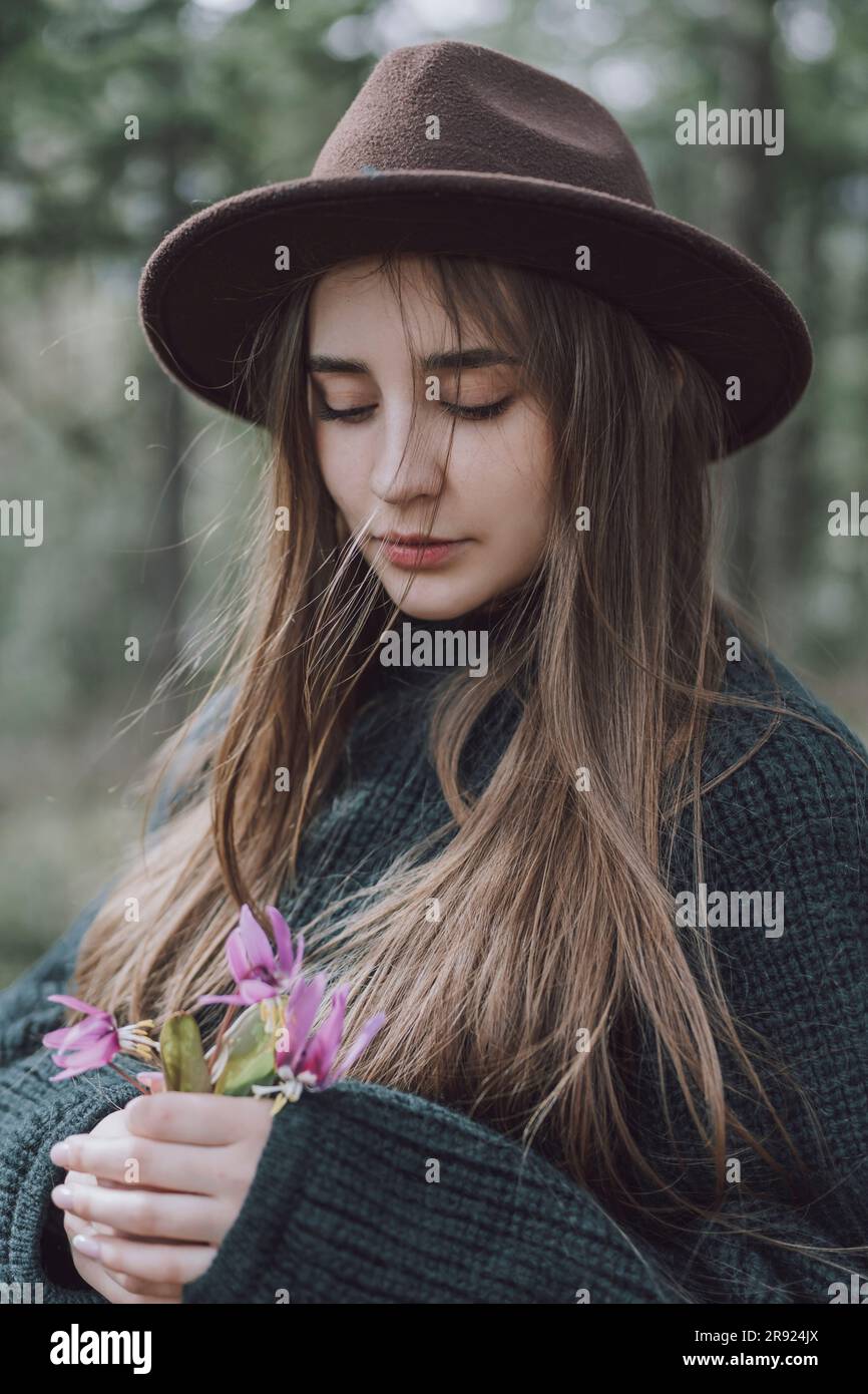 Young woman with long hair holding flowers Stock Photo