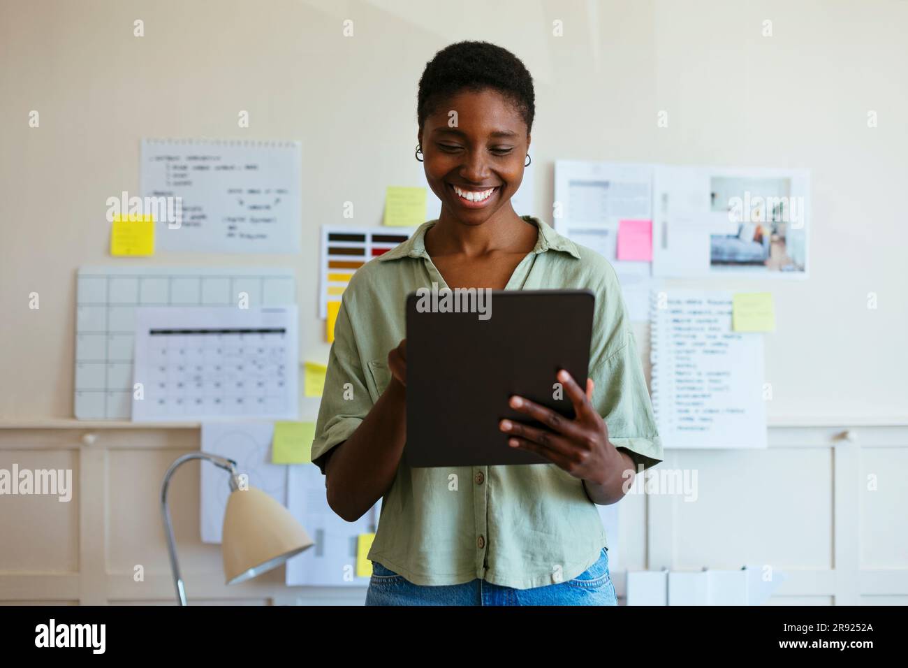 Happy freelancer using tablet PC at home office Stock Photo