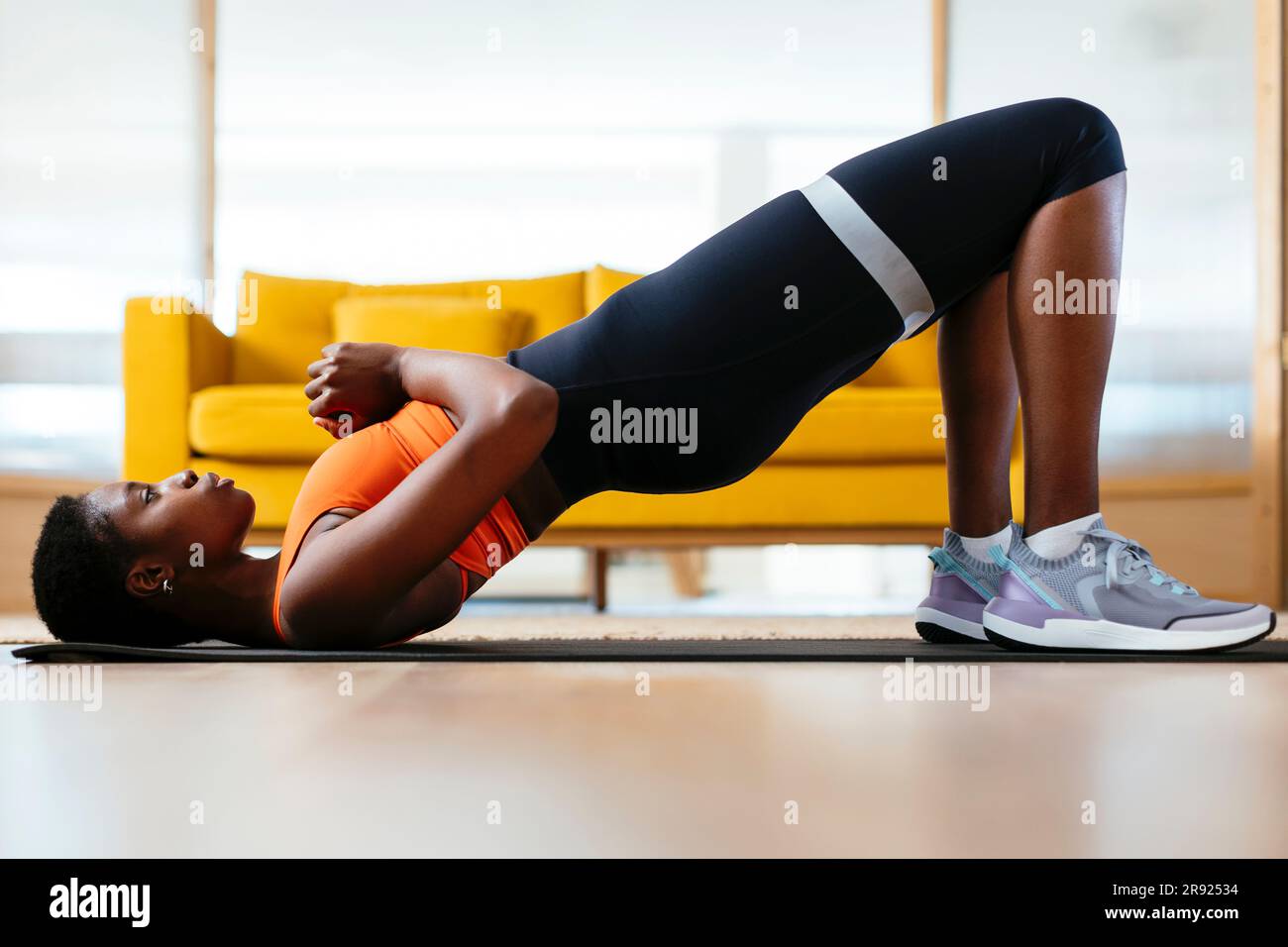 Young woman practicing bridge position at home Stock Photo