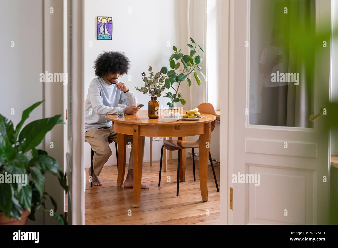 Young man using mobile phone at home Stock Photo