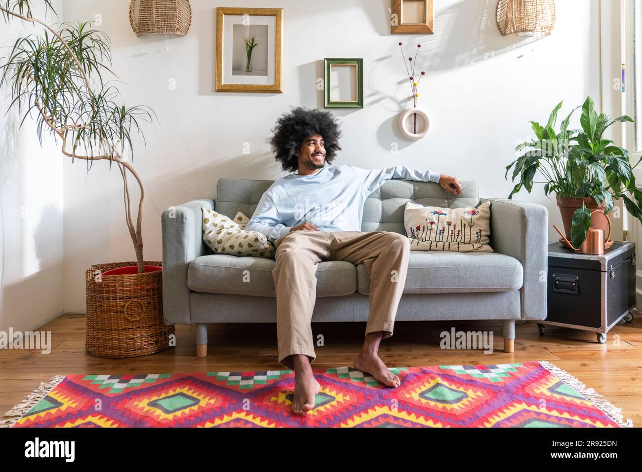 Smiling man relaxing on sofa at home Stock Photo