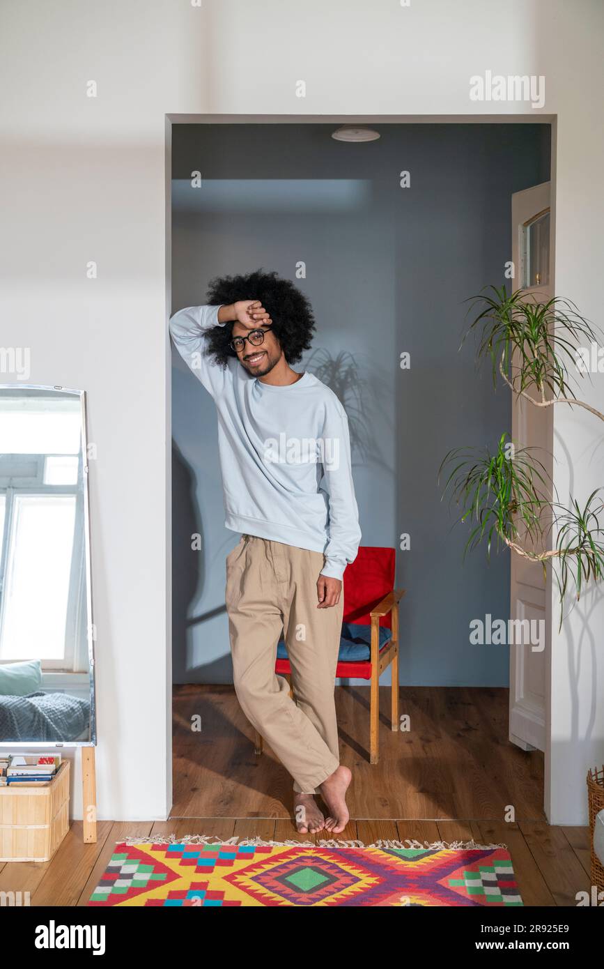 Smiling man leaning on wall at home Stock Photo