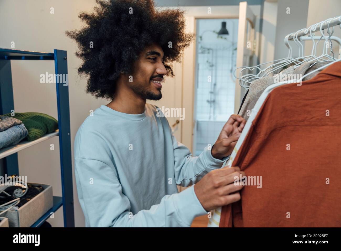 Smiling man choosing clothes at home Stock Photo