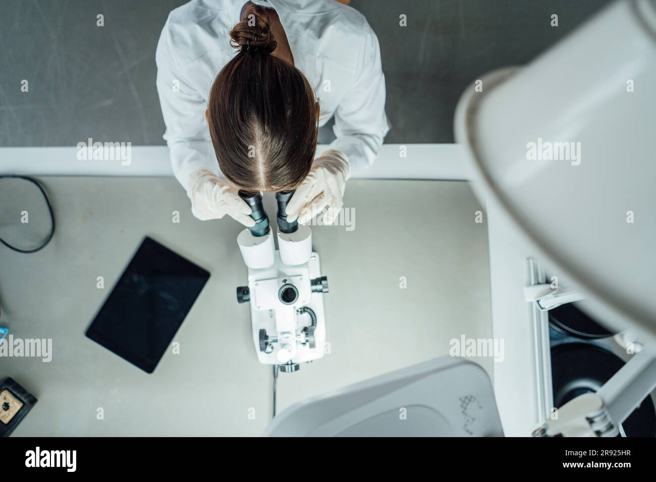 Young scientist working with microscope in laboratory Stock Photo