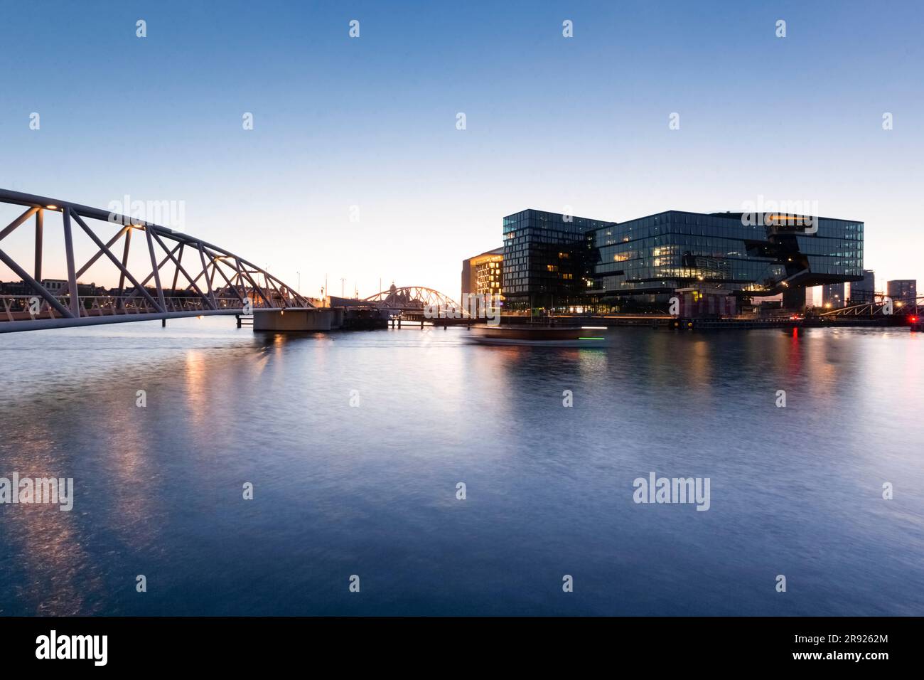 Netherlands, North Holland, Amsterdam, Bridge over city canal at dusk with modern buildings in background Stock Photo