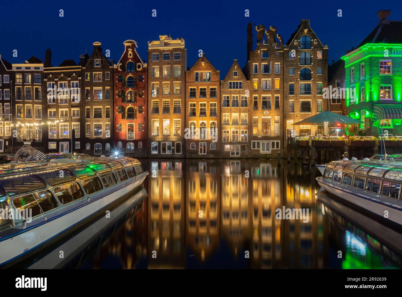 Netherlands, North Holland, Amsterdam, Row of townhouses along canal at night Stock Photo