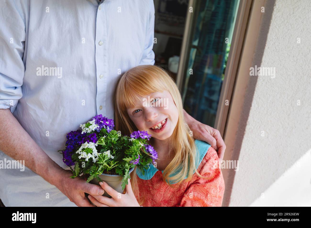 Smiling daughter holding potted plant by father Stock Photo