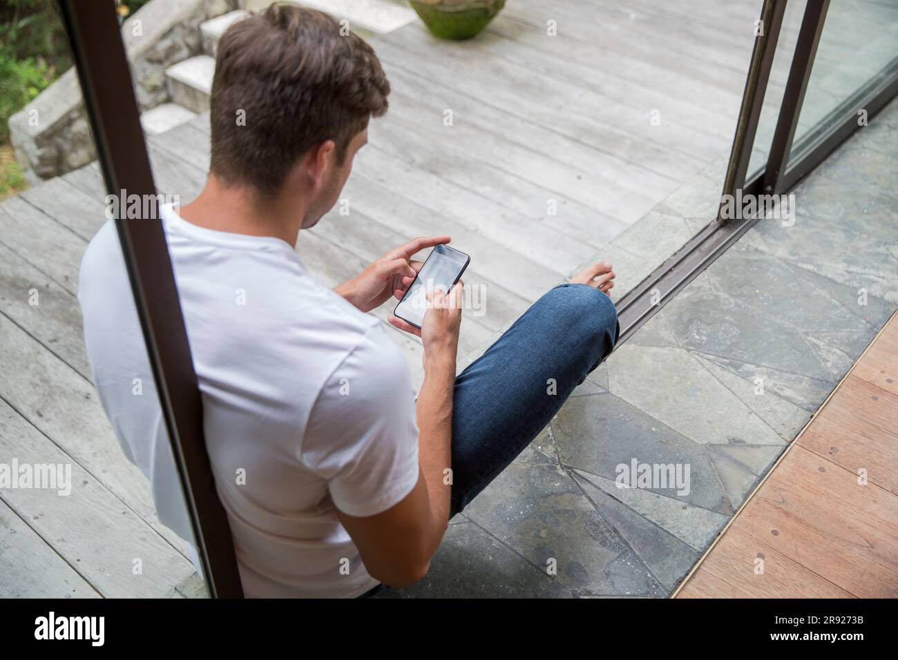 Young man using smart phone at home Stock Photo