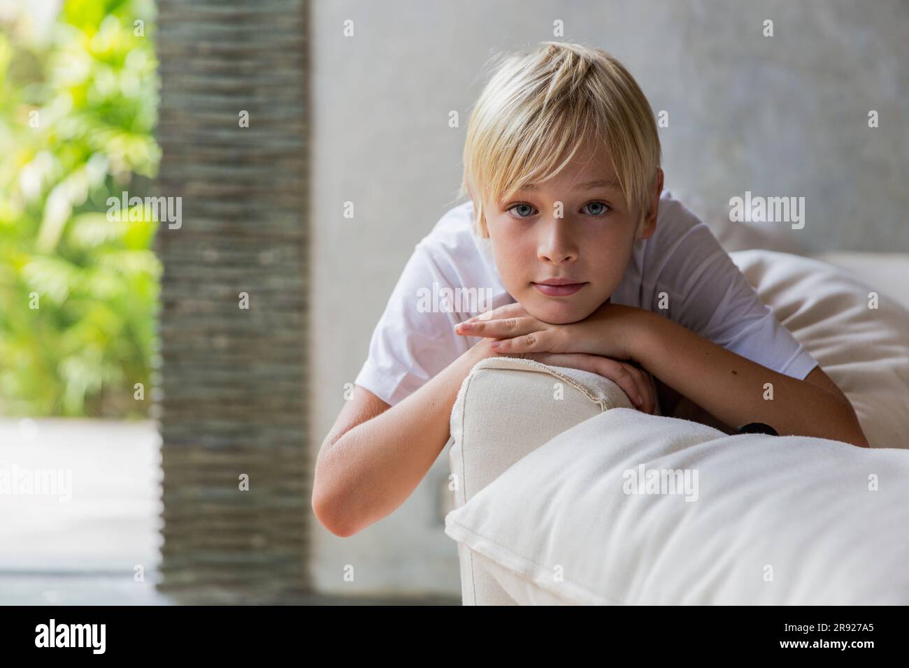 Blond boy lying on sofa at home Stock Photo