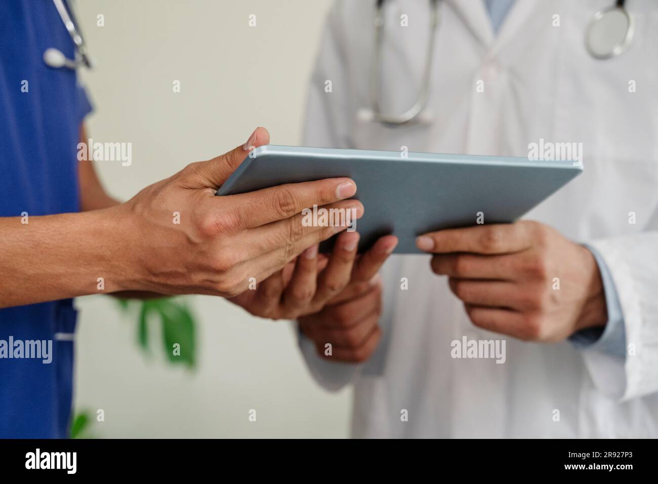 Doctors discussing over tablet PC at healthcare clinic Stock Photo