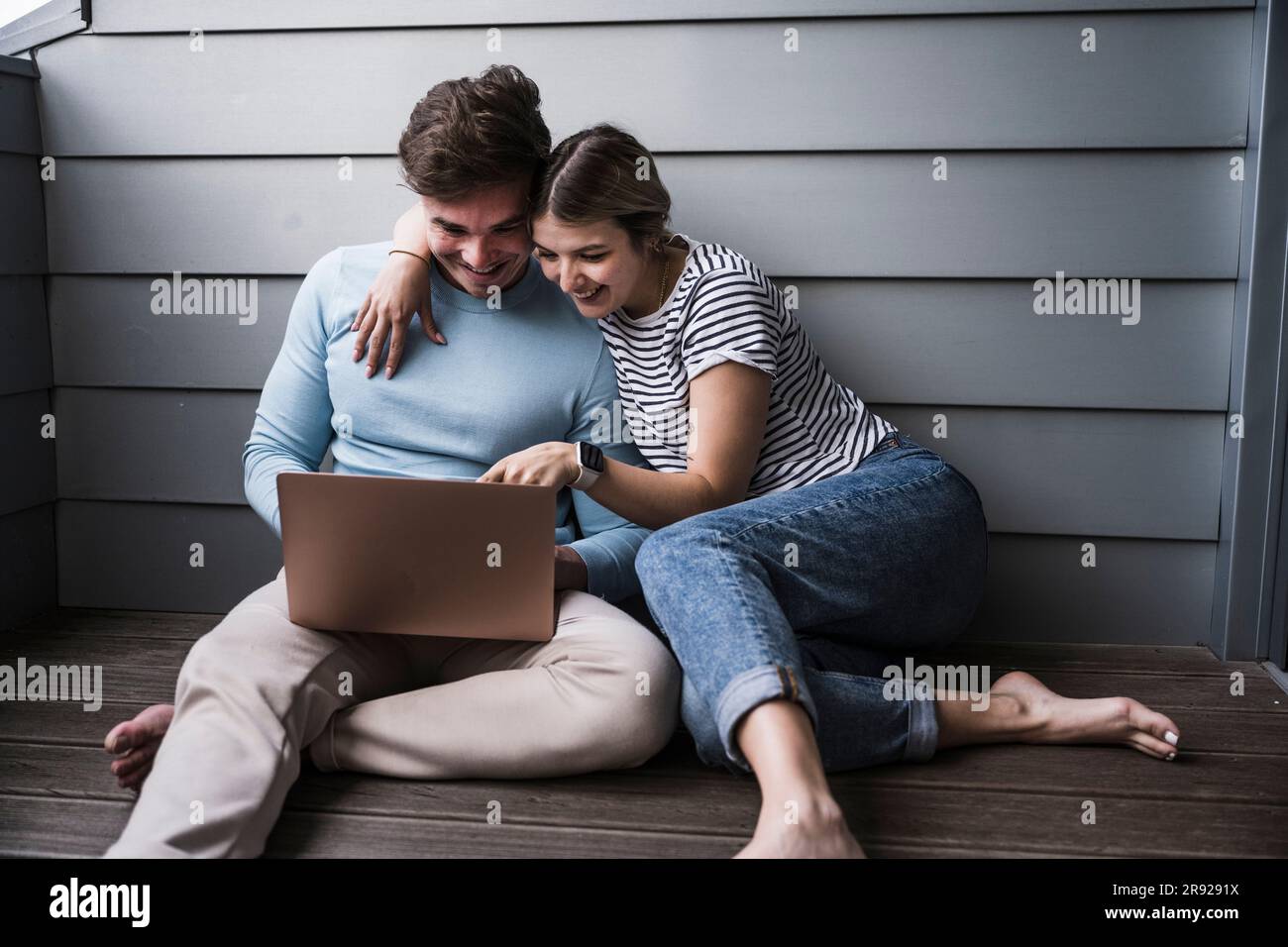 Happy young couple using laptop together Stock Photo