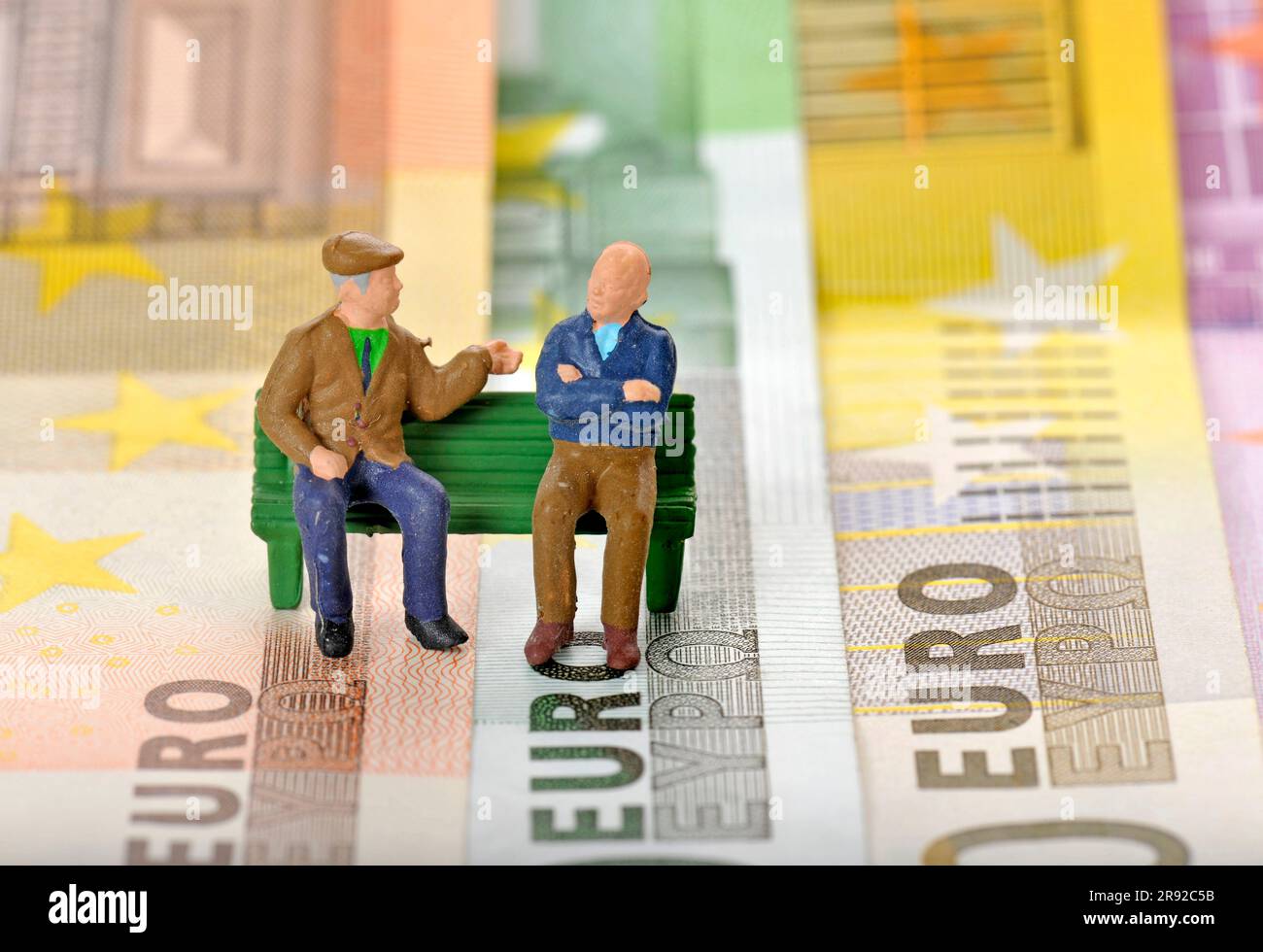 figures on euro bills, two pensioners sitting on a park bench Stock Photo