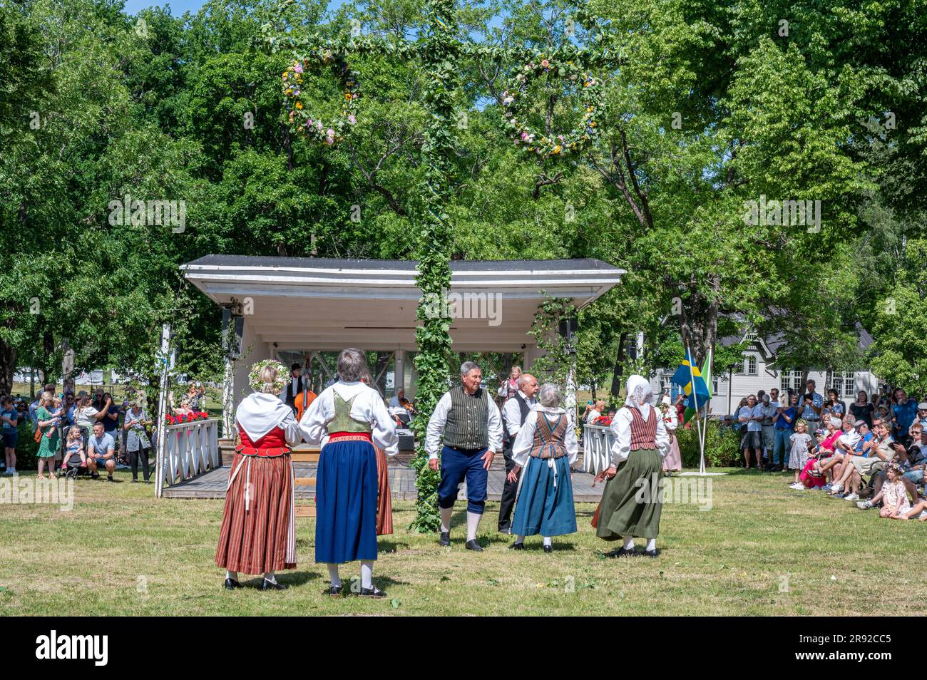 Traditional Swedish midsummer celebration with raising of the May pole ...
