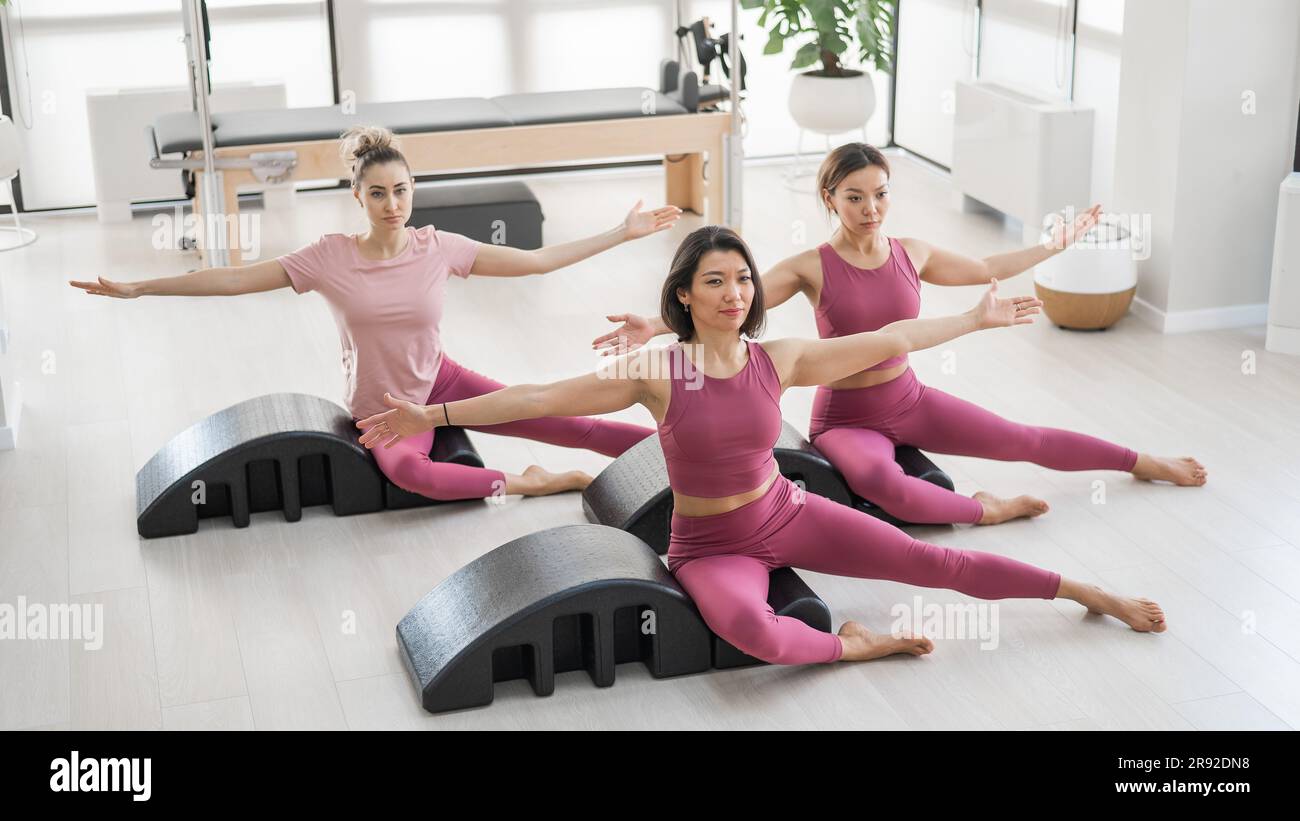 https://c8.alamy.com/comp/2R92DN8/balanced-body-pilates-arc-three-asian-women-exercising-on-pilates-arc-2R92DN8.jpg
