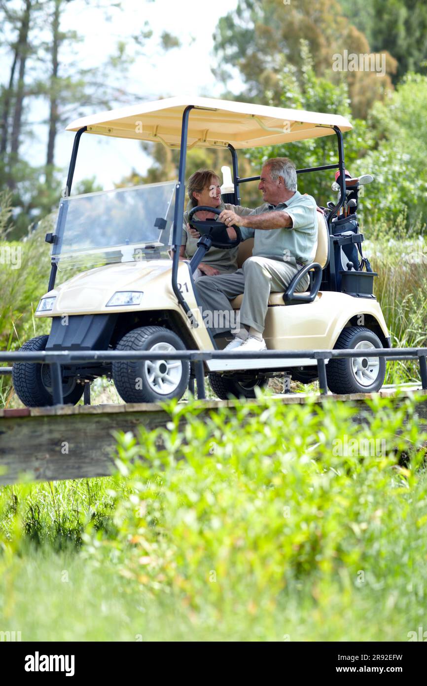 Golf cart, old couple or happy golfers driving on course in fitness workout or exercise while talking together. Mature man driver, senior woman Stock Photo