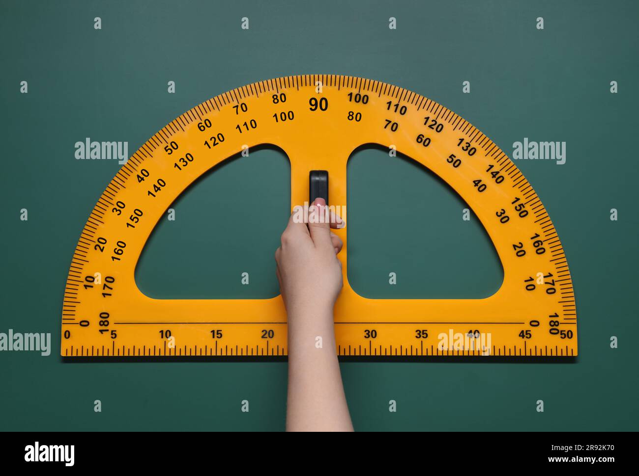 Woman holding protractor with measuring length and degrees markings