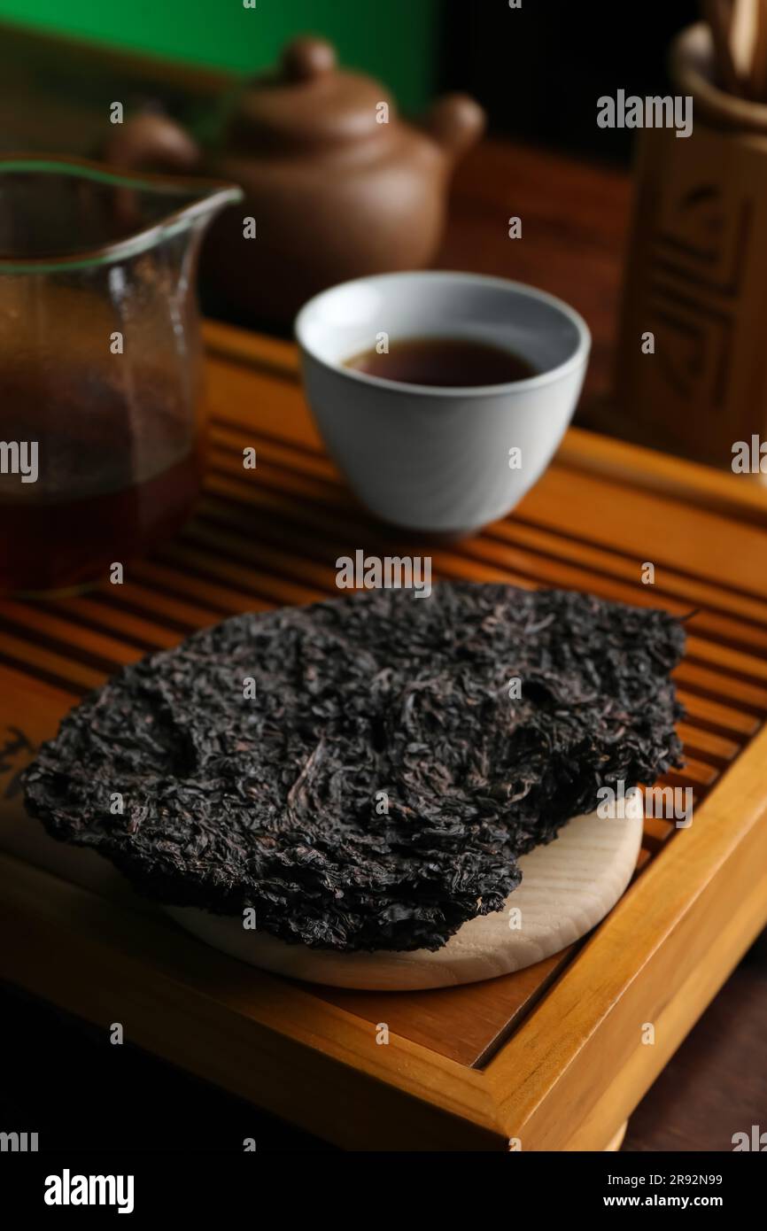 Broken disc shaped pu-erh tea on wooden tray Stock Photo
