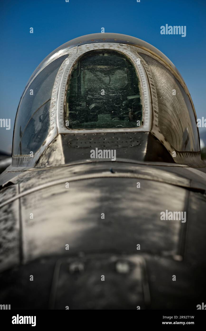 A close-up of an exterior of an old fighter jet cockpit against a clear sky Stock Photo