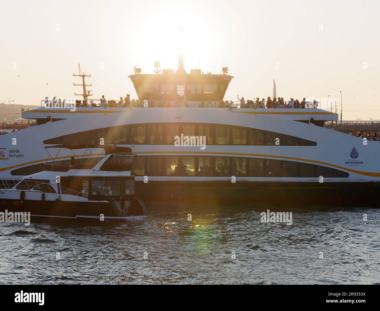 Modern Passenger Ferry with people silhouetted in the evening sun, Golden Horn River, Istanbul, Turkey Stock Photo