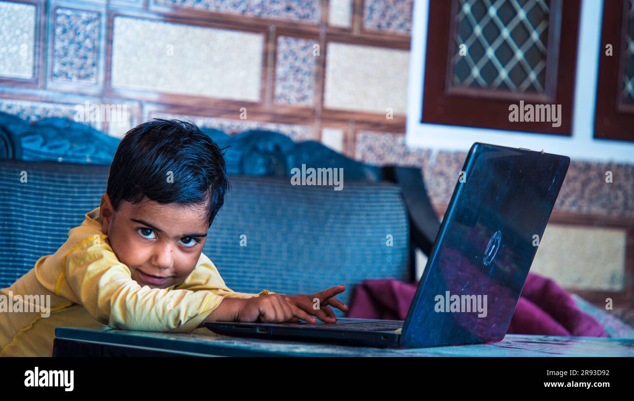 School Girl Using Laptop Wearing Earphones Smiling To Camera Learning Online At Home, Internet And Remote Education. side View, Selective Focus Stock Photo