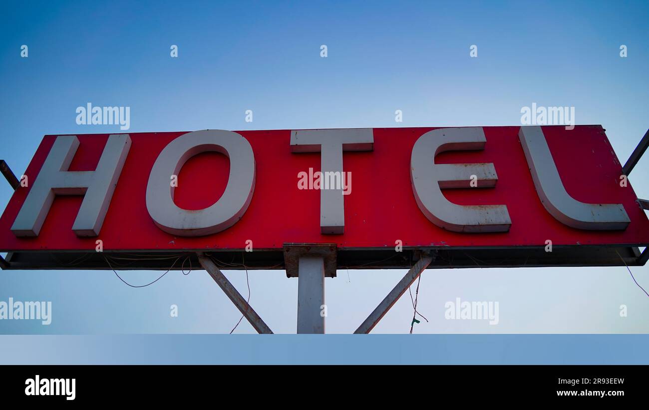 closeup on hotel sign board on building against blue sky. Sign hotel Stock Photo