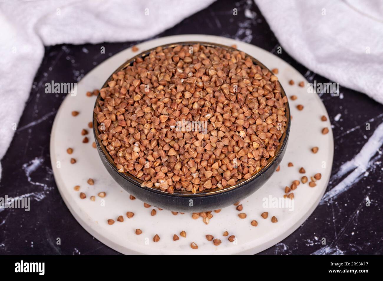Buckwheat on dark background. Buckwheat grains in bowl Stock Photo