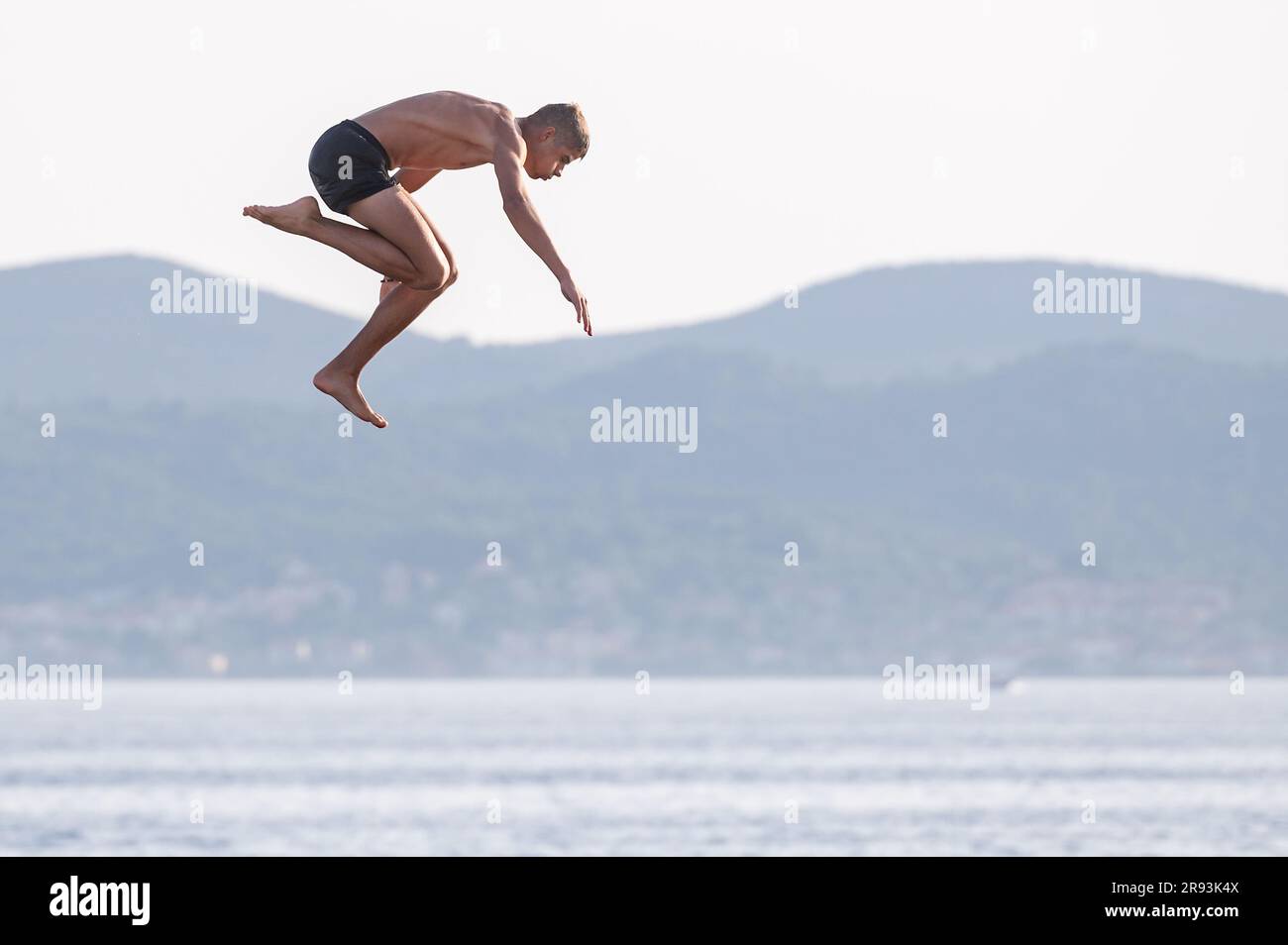 Zadar, Croatia. 23rd June, 2023. A boy jumps into sea from a top of 10