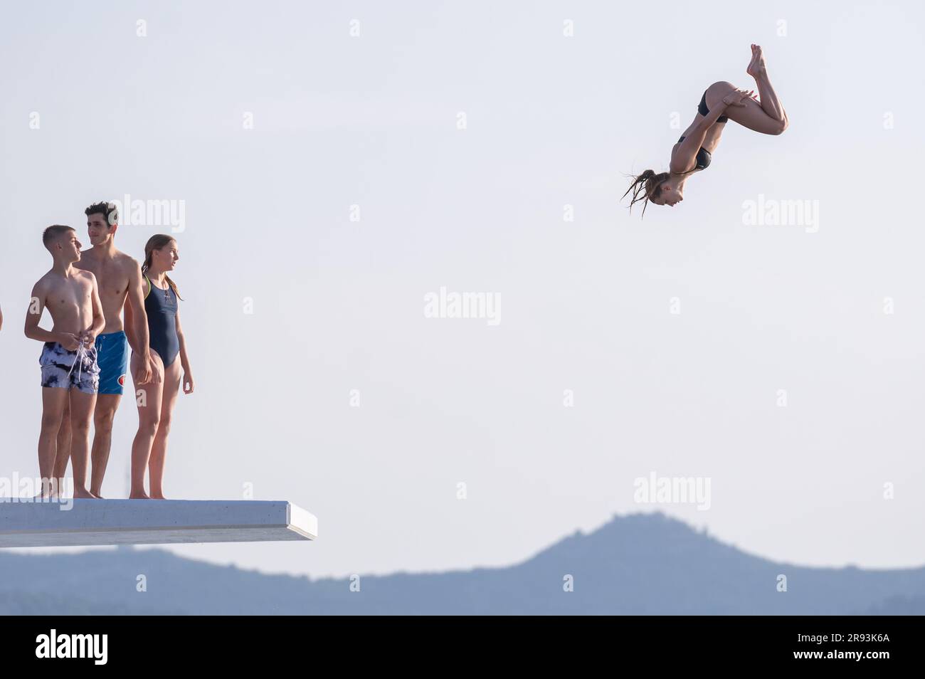 Zadar, Croatia. 23rd June, 2023. A girl jumps into sea from a top of 10