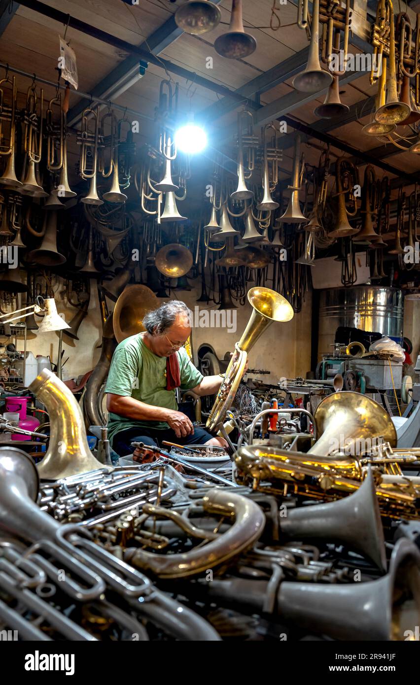 An artisan specializes in repairing and restoring brass trumpets at Nam